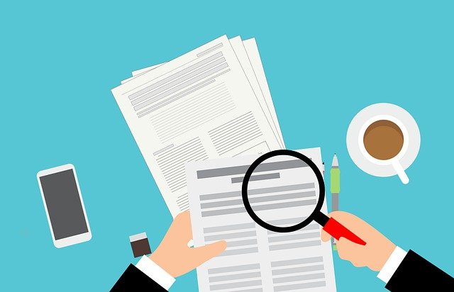 a person is holding a magnifying glass over a piece of paper